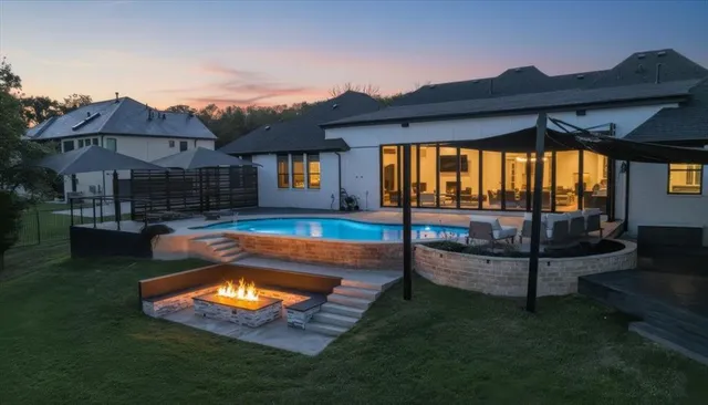a view of a house with swimming pool lawn chairs and a yard