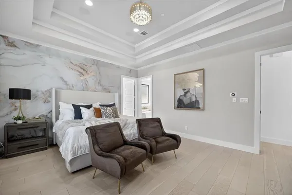 a spacious bedroom with a bed and a chandelier