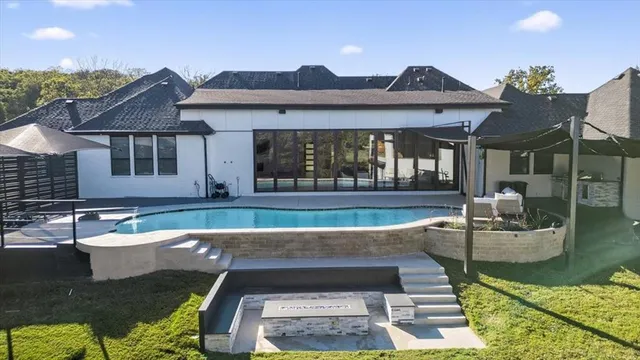 a view of a house with swimming pool and sitting area