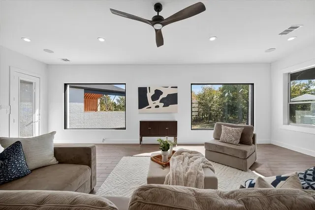 a living room with furniture a fireplace and a large window