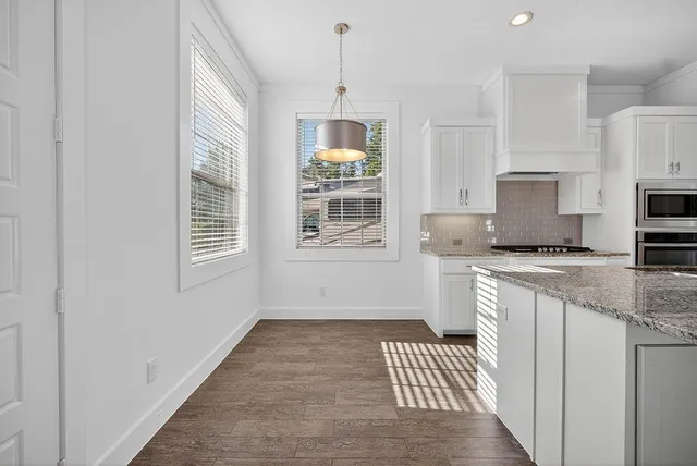 a kitchen with granite countertop a stove a sink and a granite counter top
