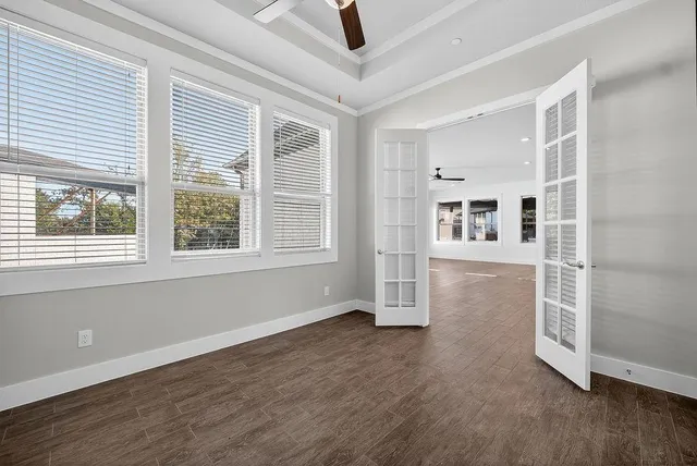 a view of empty room with wooden floor and fan