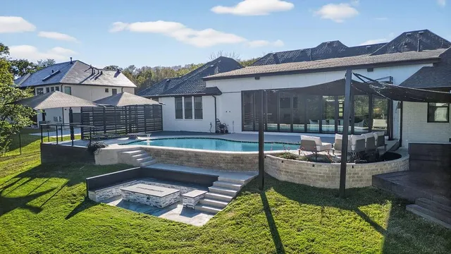 a view of a house with pool and chairs