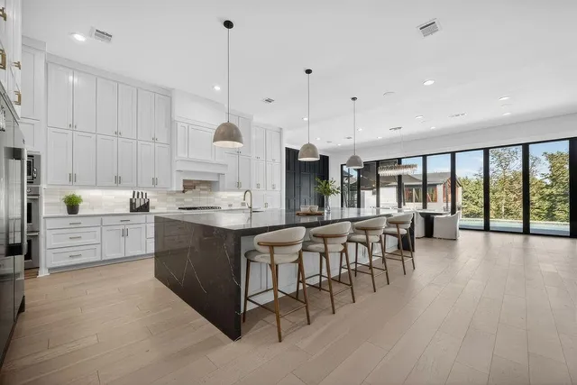 a large kitchen with lots of counter space and a wooden floor