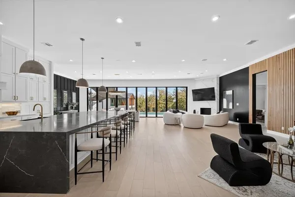 a living room with furniture kitchen view and a large window