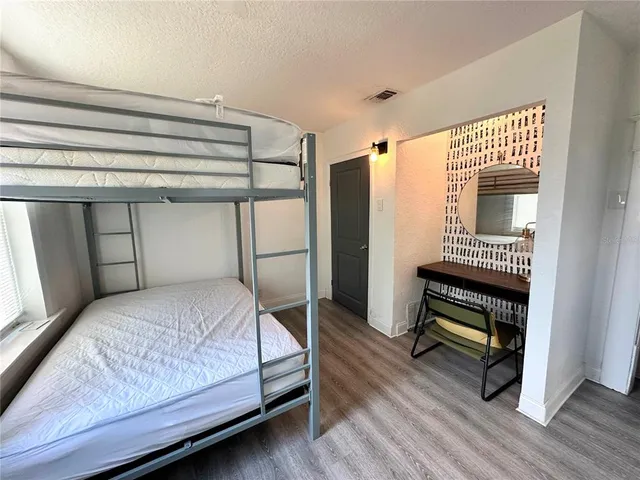 a bedroom with a bed and wooden floor