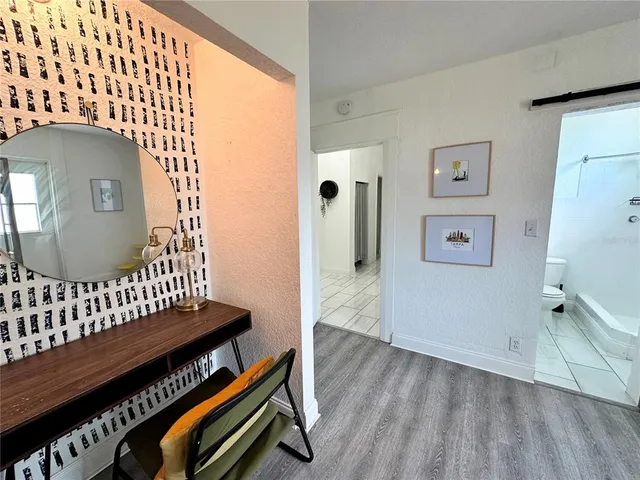 a view of a hallway with wooden floor and staircase