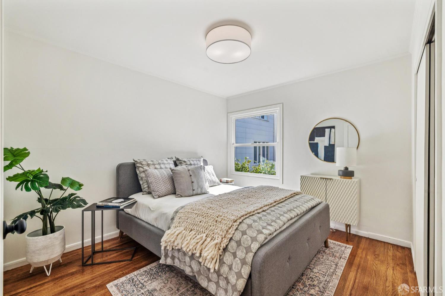 2015-2017 Judah Street San Francisco, CA 94122 - Photo 21 of 58 a large bed sitting in a bedroom next to a window with potted plant