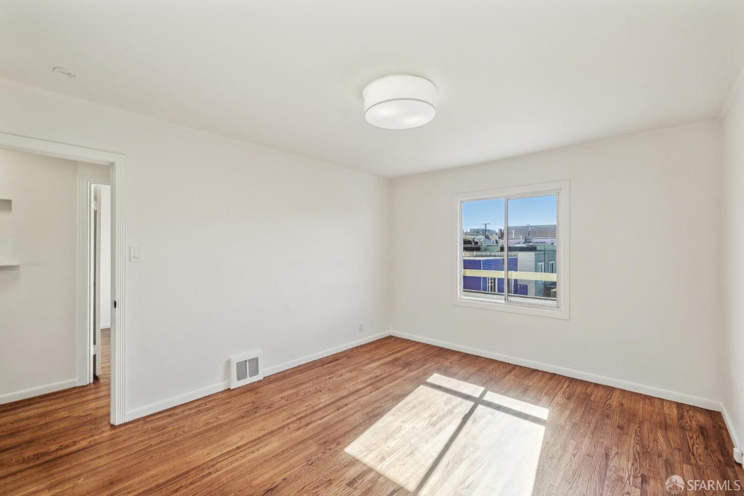2015-2017 Judah Street San Francisco, CA 94122 - Photo 45 of 58 an empty room with wooden floor and windows