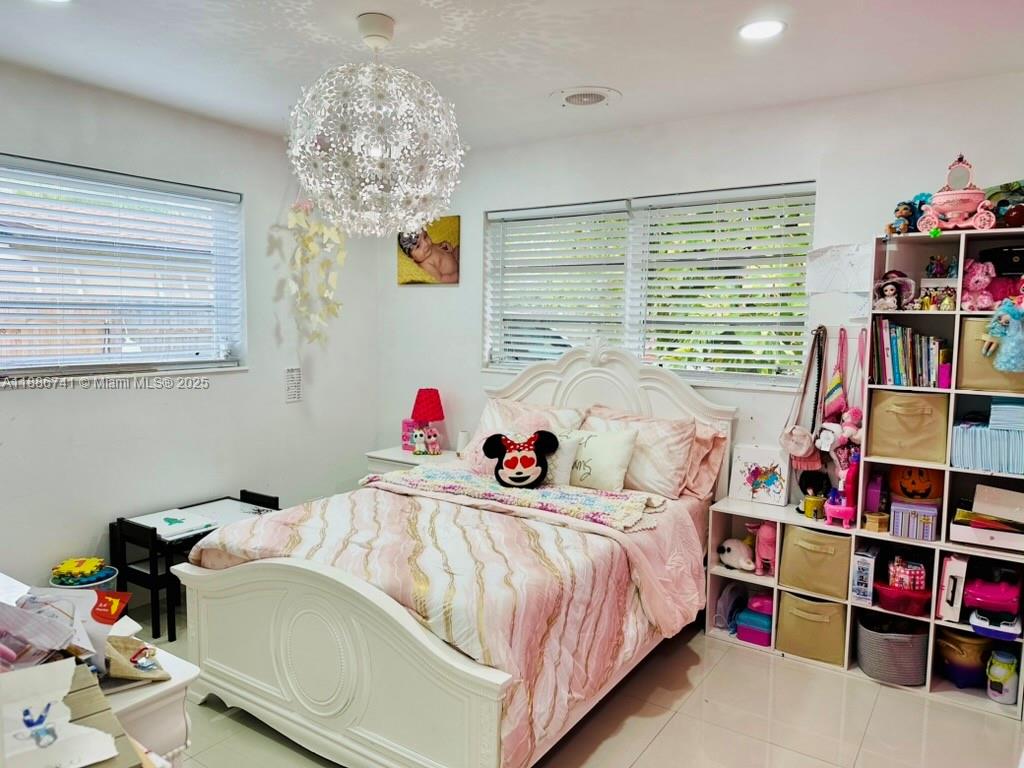 8410 Southwest 201st Street Cutler Bay, FL 33189 - Photo 24 of 33 a bedroom with bed and a book shelf