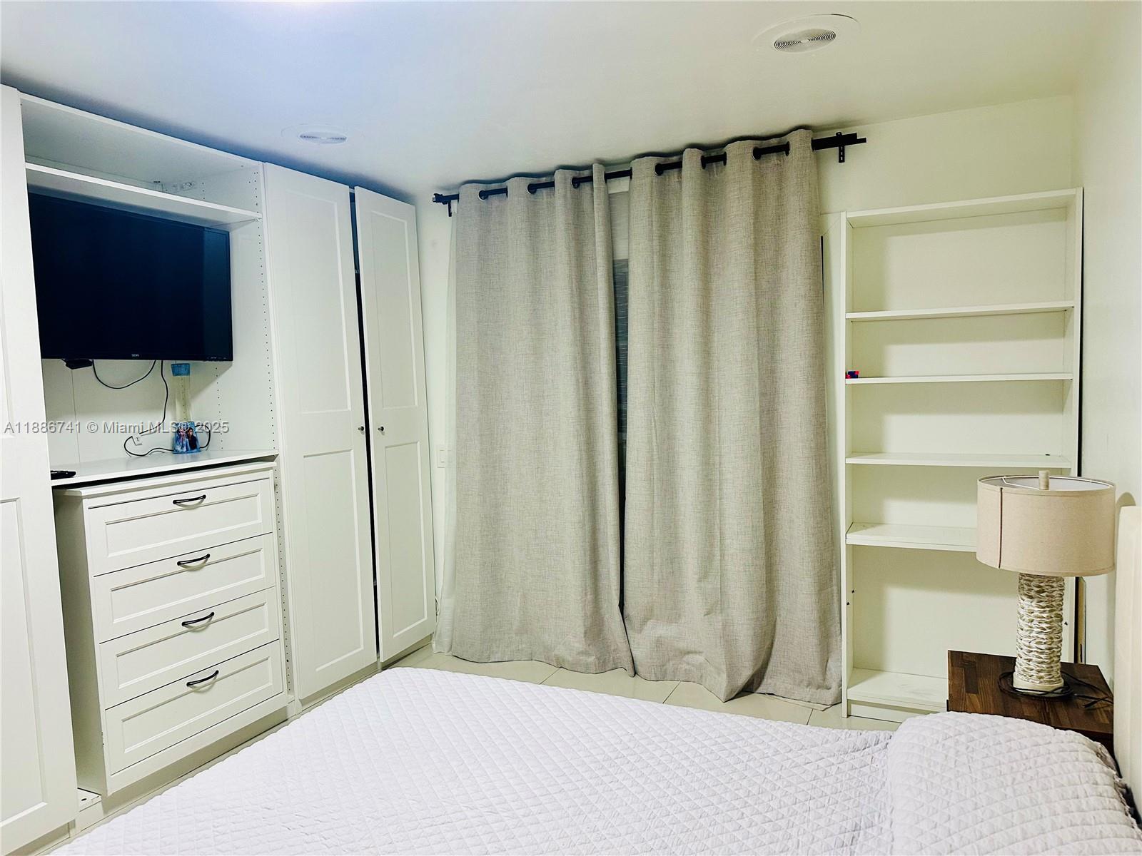 8410 Southwest 201st Street Cutler Bay, FL 33189 - Photo 26 of 33 a bedroom with a bed and a flat screen tv