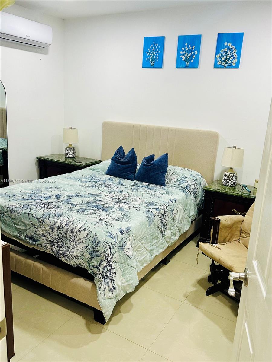 8410 Southwest 201st Street Cutler Bay, FL 33189 - Photo 27 of 33 a bed sitting in a bedroom next to a window with rug