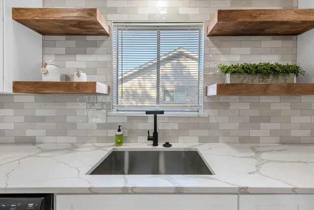 a white kitchen with a sink and a window