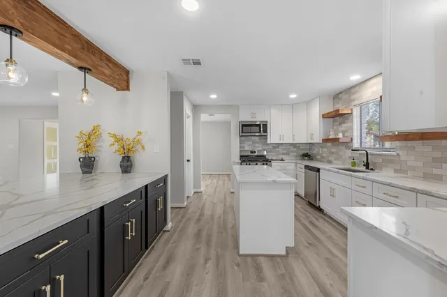 a kitchen with white cabinets appliances and sink