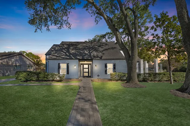 a front view of a house with a yard and trees