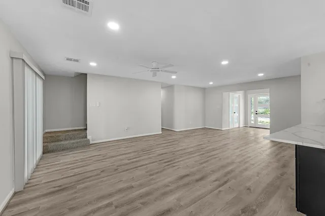 a view of an empty room with wooden floor
