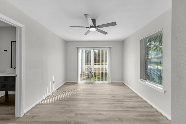 an empty room with wooden floor and windows