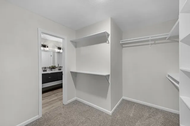 a bathroom with a tub sink vanity granite and shower