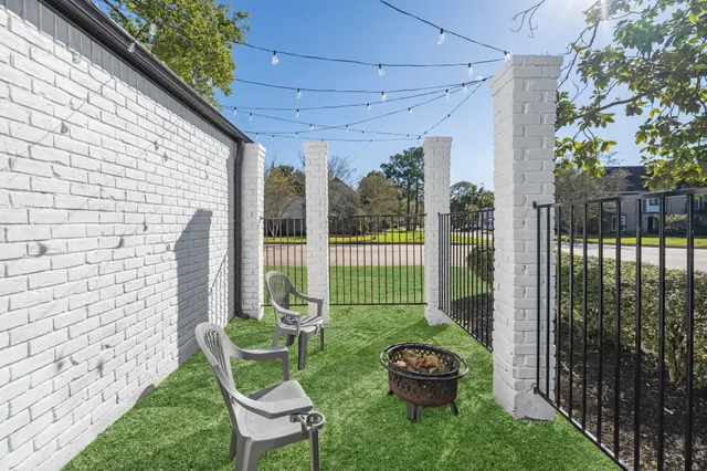 a view of a chair and table in backyard of the house