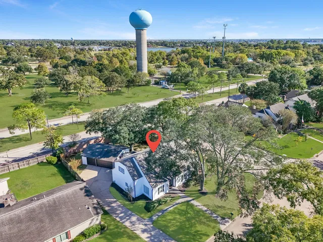 an aerial view of a house with a yard and lake view