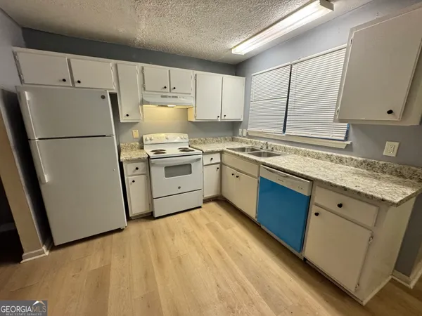 a kitchen with a sink a refrigerator and cabinets