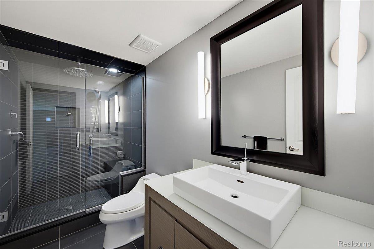1422 Galena Rochester, MI 48306 - Photo 60 of 73 Contemporary bathroom featuring a frameless glass shower enclosure with dark gray tile, a wall-mounted rainfall showerhead, and a built-in shower bench