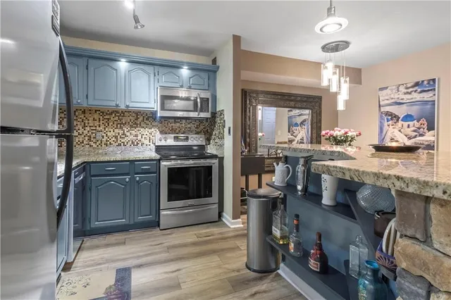 a kitchen with granite countertop a sink appliances and cabinets