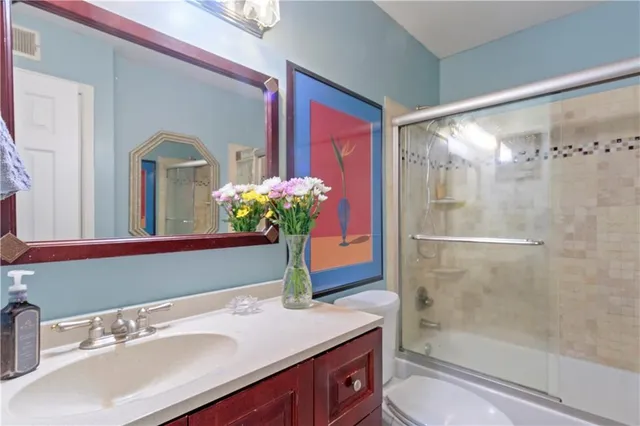 a bathroom with a sink shower and a mirror