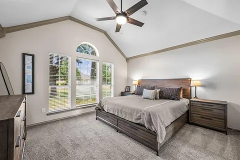 a bedroom with a large bed and a chandelier