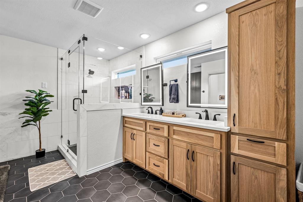 9624 Wells Road Wylie, TX 75098 - Photo 12 of 25 a spacious bathroom with a double vanity sink a mirror and a shower