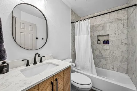 a bathroom with a sink a toilet and a mirror