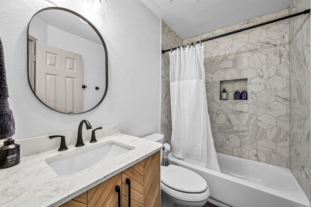 9624 Wells Road Wylie, TX 75098 - Photo 17 of 25 a bathroom with a sink a toilet and a mirror
