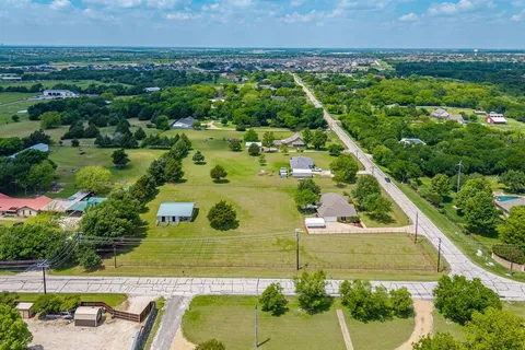 an aerial view of a house with a yard and lake view