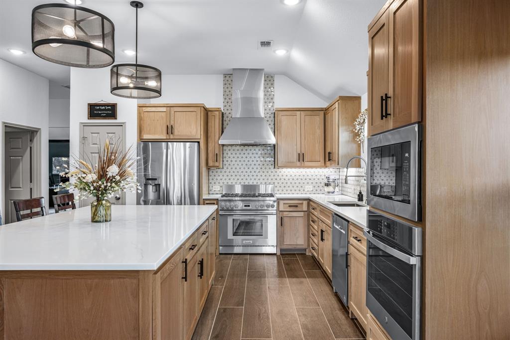 9624 Wells Road Wylie, TX 75098 - Photo 4 of 25 a kitchen with stainless steel appliances granite countertop a sink refrigerator and cabinets