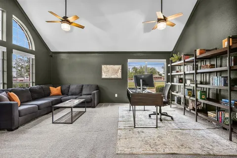 a living room with furniture a rug and a bookshelf