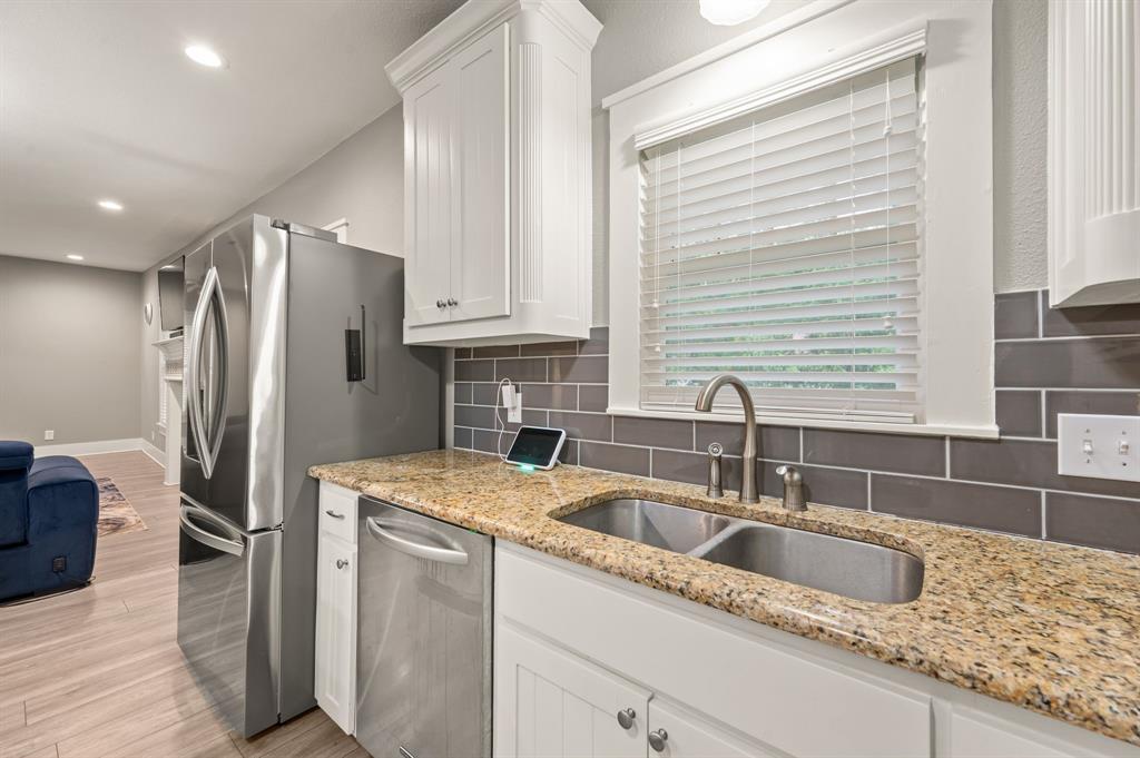 800 North Clements Street Gainesville, TX 76240 - Photo 12 of 27 a kitchen with stainless steel appliances granite countertop a sink refrigerator and cabinets
