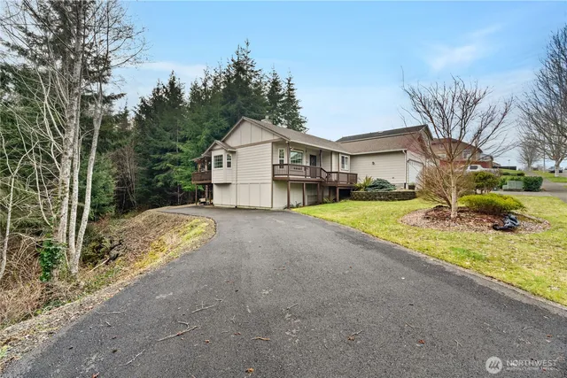 a view of a house with a big yard and large trees