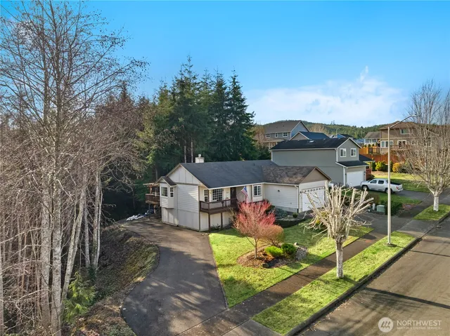 a view of a white house with a big yard and large tree