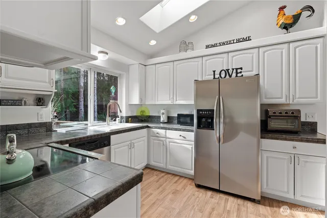 a kitchen with stainless steel appliances a stove a sink and a refrigerator