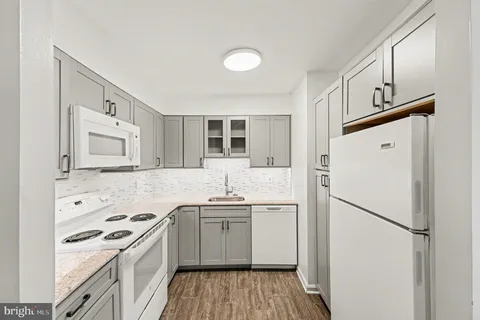 a kitchen with granite countertop a sink stove and refrigerator