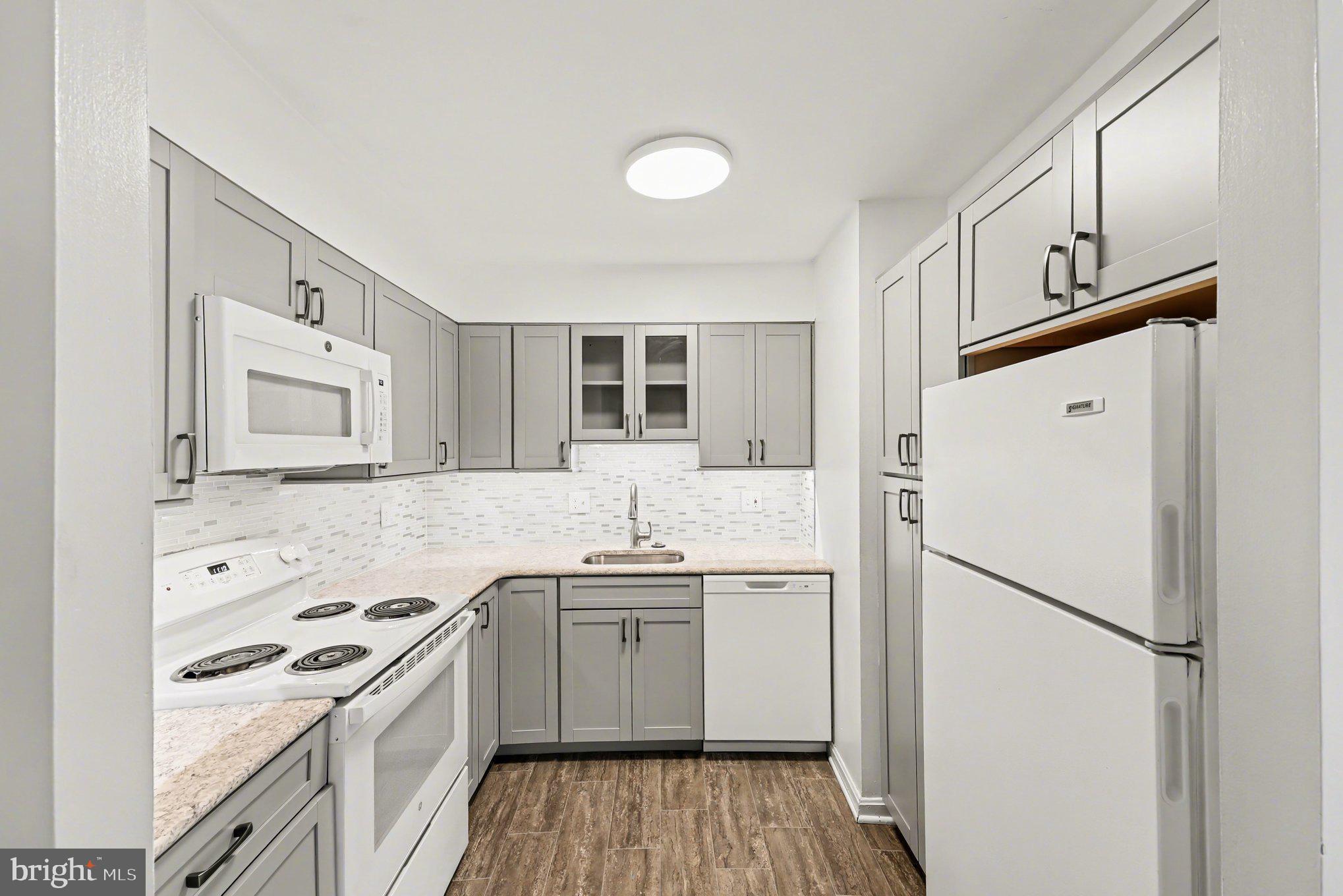 6141 Edsall Road, Unit L Alexandria, VA 22304 - Photo 3 of 18 a kitchen with granite countertop a sink stove and refrigerator
