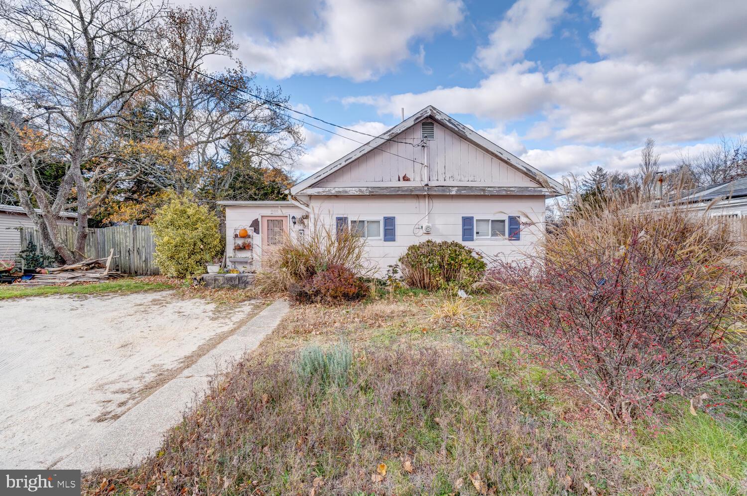 a view of a house with a yard and large tree