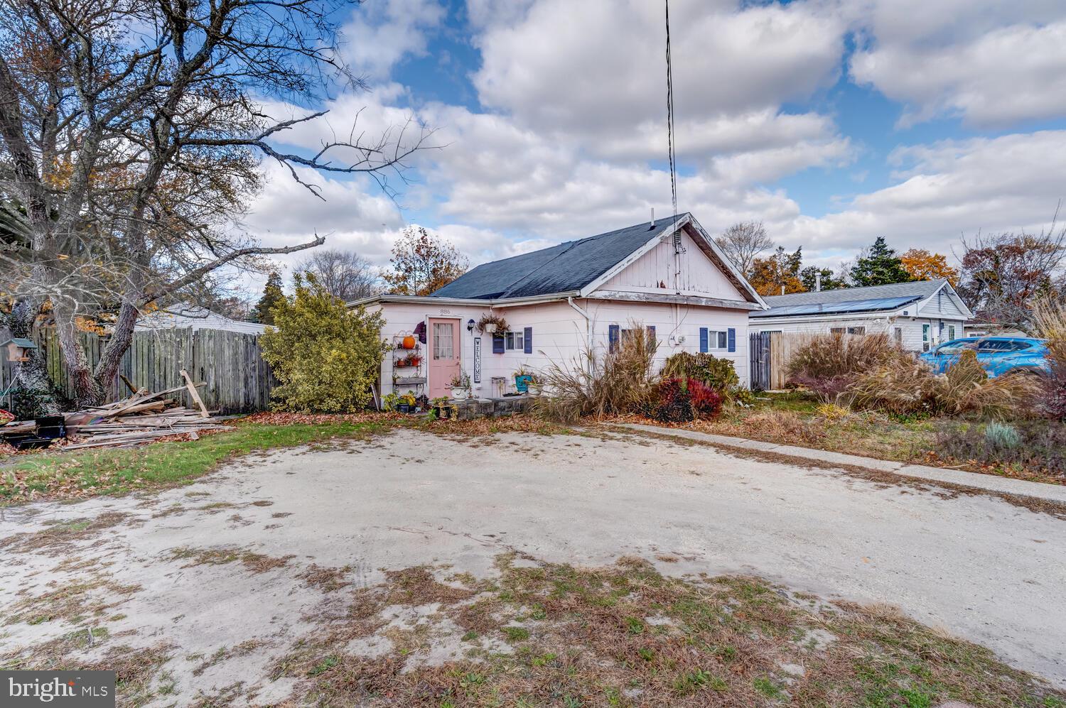 886 Radio Road Little Egg Harbor, NJ 08087 - Photo 3 of 22 a front view of a house with a dirt yard and a garage