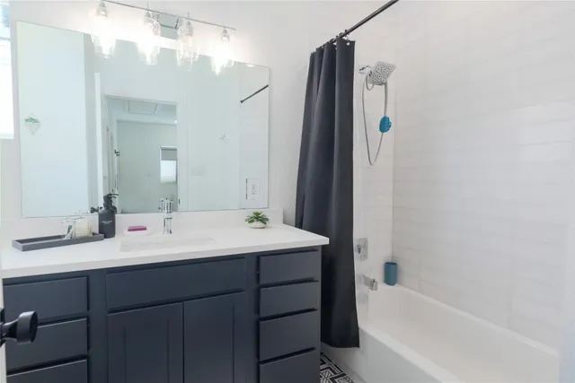 a bathroom with a tub sink and mirror