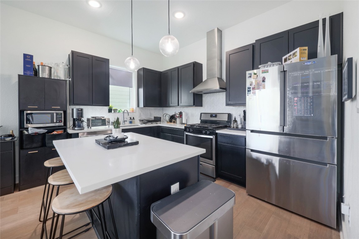 5820 Sutherlin Road, Unit 17 Austin, TX 78723 - Photo 4 of 15 a kitchen with stainless steel appliances a refrigerator a sink a stove a dining table and chairs