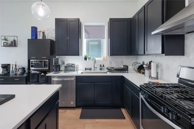 a kitchen with a sink stove top oven and cabinets