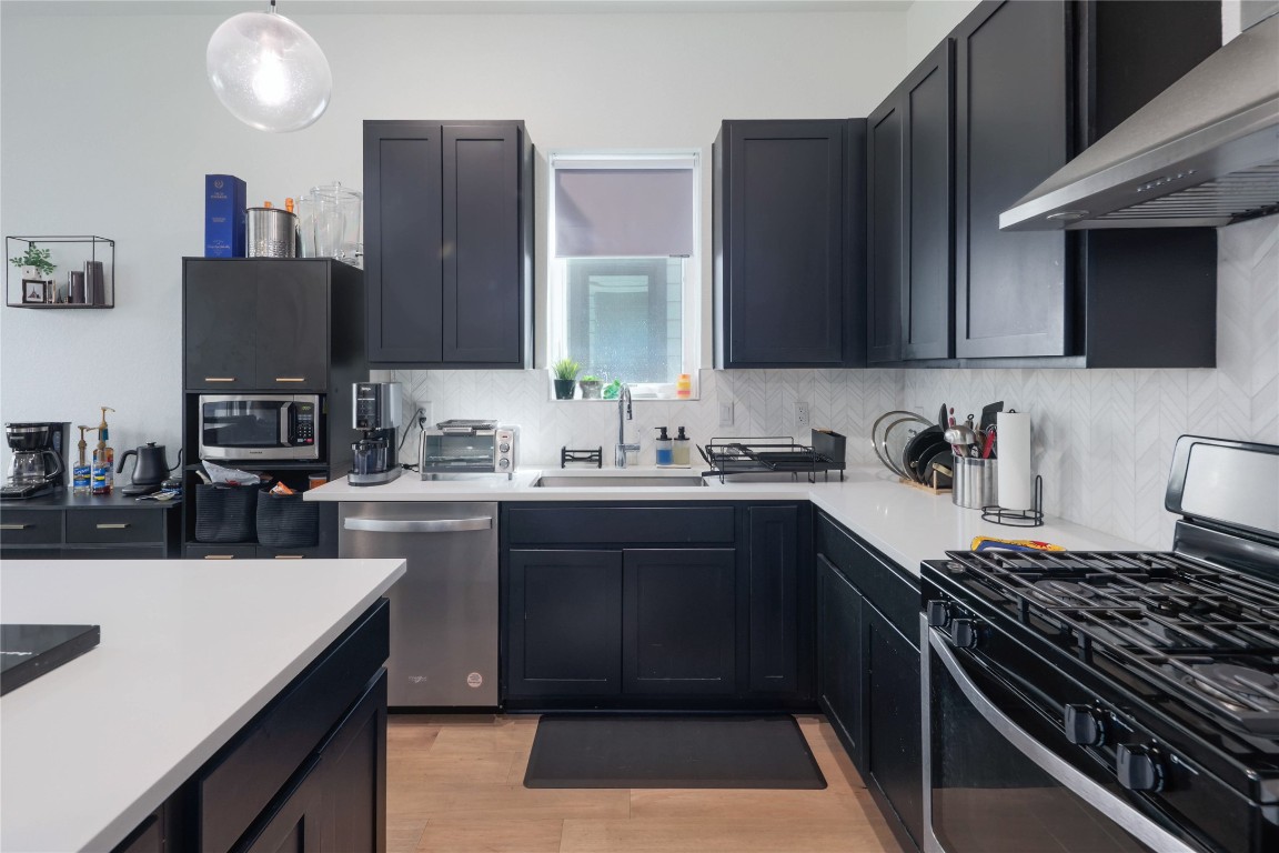 5820 Sutherlin Road, Unit 17 Austin, TX 78723 - Photo 5 of 15 a kitchen with a sink stove top oven and cabinets