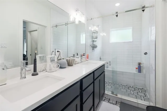 a bathroom with a double vanity sink mirror and shower
