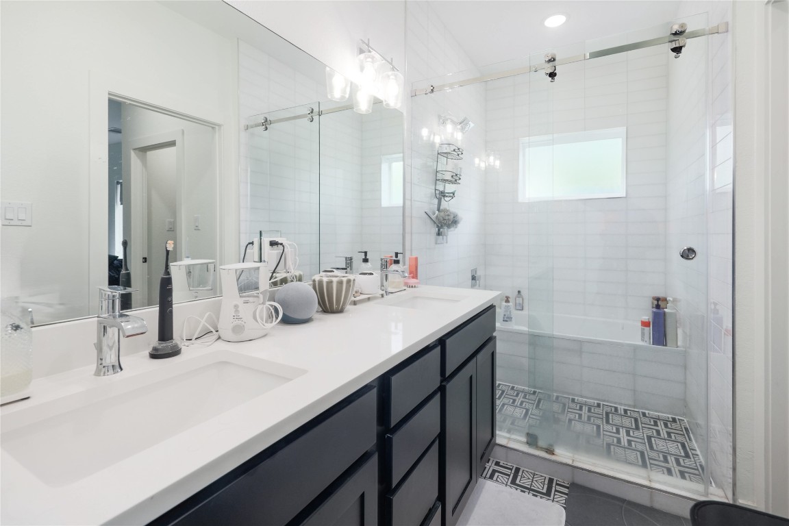 5820 Sutherlin Road, Unit 17 Austin, TX 78723 - Photo 10 of 15 a bathroom with a double vanity sink mirror and shower