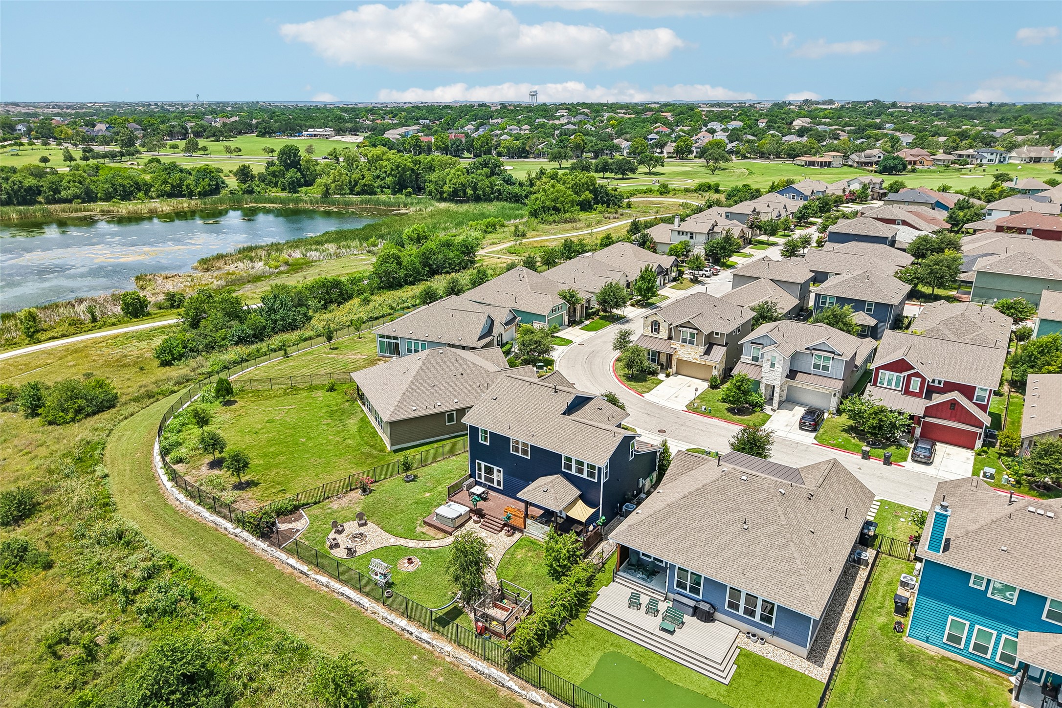 1297 Harwell Loop Kyle, TX 78640 - Photo 38 of 39 An aerial perspective reveals a vibrant neighborhood bordered by a tranquil lake and verdant golf course.